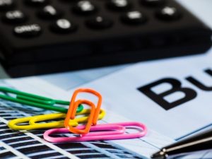 LearnOnline Self-study IGCSE Business Studies - close up colourful paperclips, pen and calculator