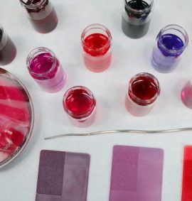 LearnOnline Self-study IGCSE Chemistry - birds eye view of laboratory dishes with liquids and powders all in tones of pink