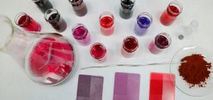 LearnOnline Self-study IGCSE Chemistry - birds eye view of laboratory dishes with liquids and powders all in tones of pink