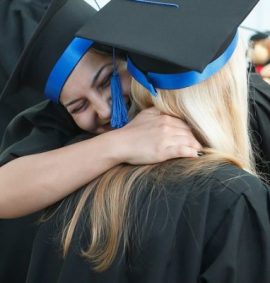 LearnOnline UCAS - two people in graduation cap and gown hugging