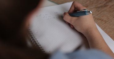 LearnOnline news article - is an IGCSE the same as a GCSE? someone writing on grid paper