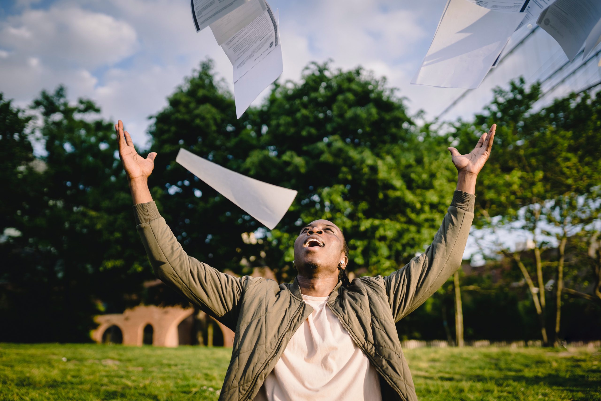 LearnOnline Home Education - results Young man throwing paper in the air in delight