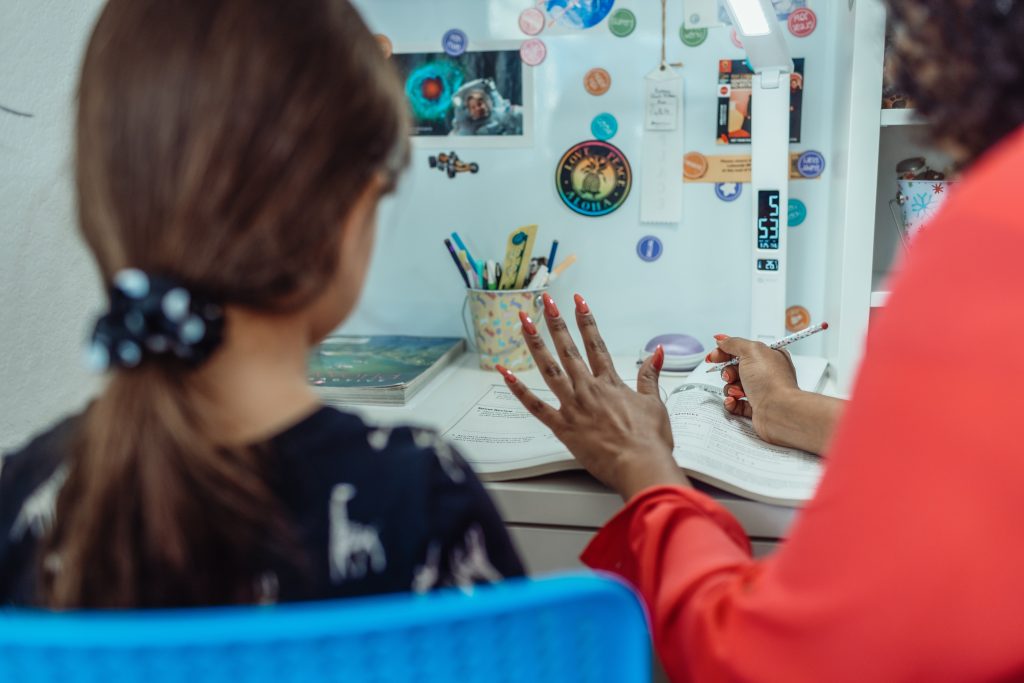 LearnOnline News Article - can I teach my child IGCSEs at home? Adult and child sat in kitchen studying