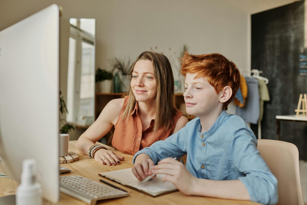 LearnOnline Maths and English IGCSE Package. Mother and son looking at computer together
