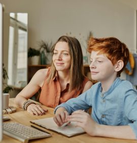 LearnOnline Maths and English IGCSE Package. Mother and son looking at computer together
