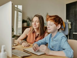 LearnOnline Maths and English IGCSE Package. Mother and son looking at computer together