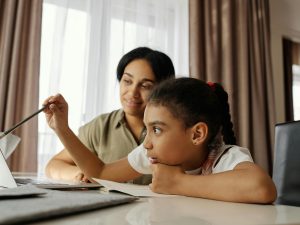 LearnOnline Science IGCSE Package. Mother and daughter reading something on computer