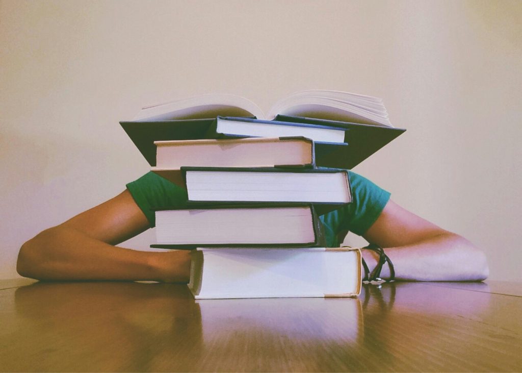 LearnOnline Course Packages: pile of books with someone behind